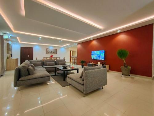 a living room with couches and a flat screen tv at Le spacieux bord de mer in Dakan