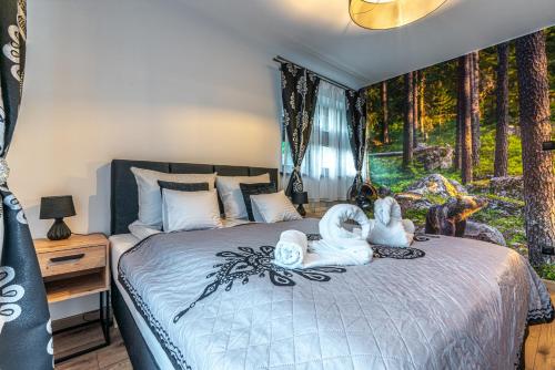 a bedroom with a bed with two swans on it at Giewont View Apartamenty z widokiem Seven & Sauna - Grunwaldzka Krupówki Centrum by RentiloPL in Zakopane
