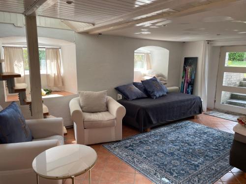 a living room with a bed and a couch and chairs at Huset på hörnet in Hammenhög