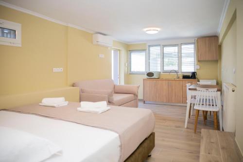 ポルト・ラフティにあるHelios Apartments Porto Raftiのベッドとソファとテーブルのある寝室