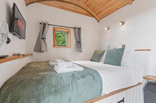 a bedroom with a bed with towels on it at Hot Tub Luxury Glamping - Private Stargazing Patio in Yarpole
