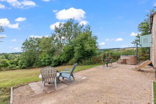 a patio with two chairs and a table at Hot Tub Luxury Glamping - Private Stargazing Patio in Yarpole