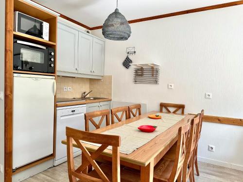 a kitchen and dining room with a wooden table and chairs at DATCHA Joséphine Immobilier in La Salle Les Alpes
