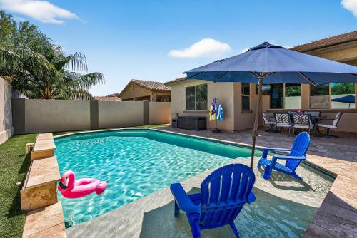 a swimming pool with two chairs and an umbrella at The Revel House in Phoenix