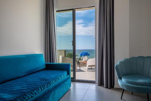 a living room with a couch and a chair at Resort La Battigia Beach & Spa in Alcamo Marina