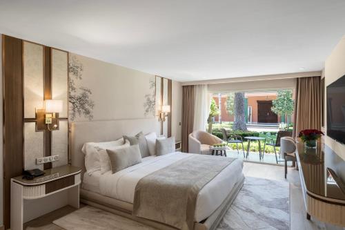 a hotel room with a bed and a balcony at Savoy Le Grand Hotel Marrakech in Marrakech