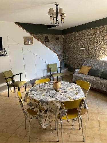 a living room with a table and chairs and a couch at Maison paisible Noël et Rosalie 