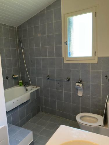 a bathroom with a toilet and a sink and a tub at Maison paisible Noël et Rosalie 