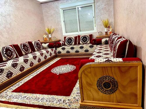 a living room with a couch and a red rug at app entre aéroport M5 et nearshore sidi maarouf in Bouskoura