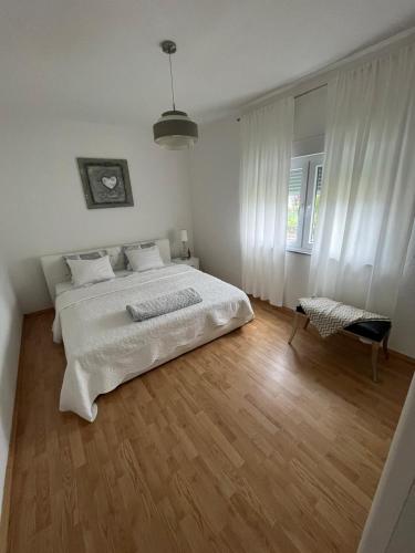 a bedroom with a white bed and a wooden floor at Villa Pliva Oasis in Jezero