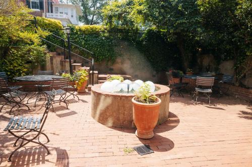 a patio with a fountain with chairs and tables at Ironclad Inn and Bourbon Room in Fredericksburg