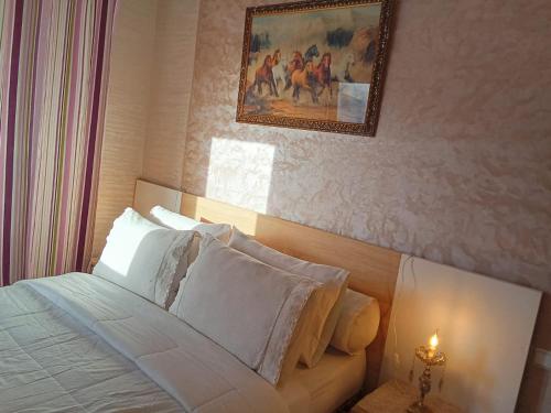 a bedroom with a bed with a painting on the wall at Résidence Al Qaraouiyine in Fès