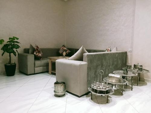 a living room with a couch and two tables at Résidence Al Qaraouiyine in Fès
