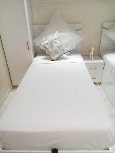 a white bed with a pillow on top of it at Résidence Al Qaraouiyine in Fès