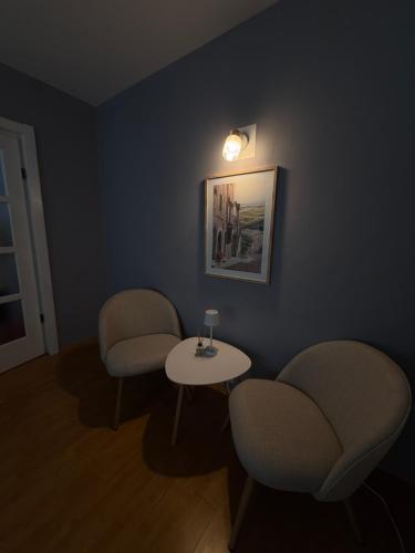a waiting room with two chairs and a table at Garsonieră modernă în Zarnesti in Zărneşti