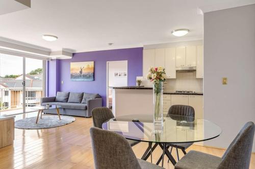 a living room with a glass table and chairs at 73R Abnb-Style Apartment-Quiet, Pool&Gym, Parking & 10mins drive to Centennial in Sydney