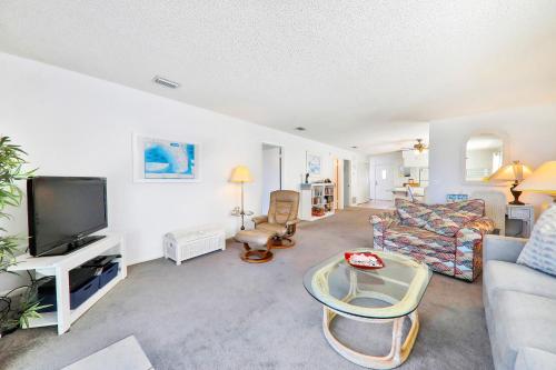 Μια τηλεόραση ή/και κέντρο ψυχαγωγίας στο Oceanfront condo with private beach access in a perfect location