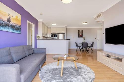 a living room with a couch and a table at 73R Abnb-Style Apartment-Quiet, Pool&Gym, Parking & 10mins drive to Centennial in Sydney