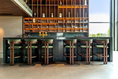 a bar with green stools in a room at Hotel Loa in Hvolsvöllur
