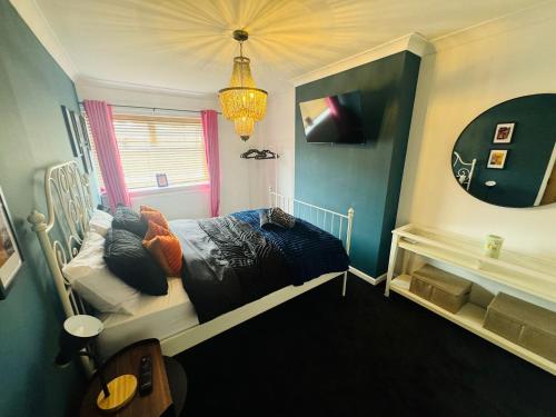 a bedroom with a bed and a mirror at Marine Cottage 1 - With Private Hot Tub in Newbiggin-by-the-Sea