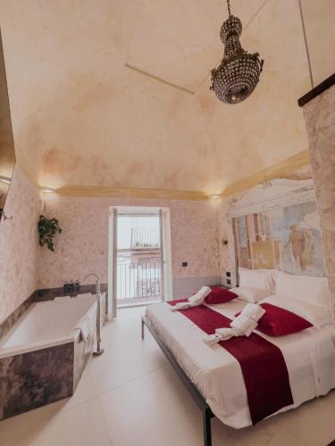 a bedroom with a large bed and a bath tub at Odeon Neapolis - Historic Suites in Roman Theater in Naples