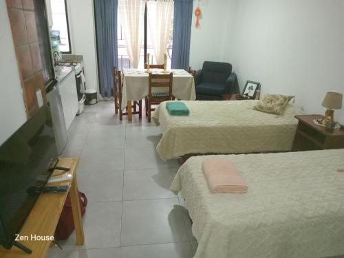una stanza con tre letti, un tavolo e una cucina di Zen house Bs As a Buenos Aires