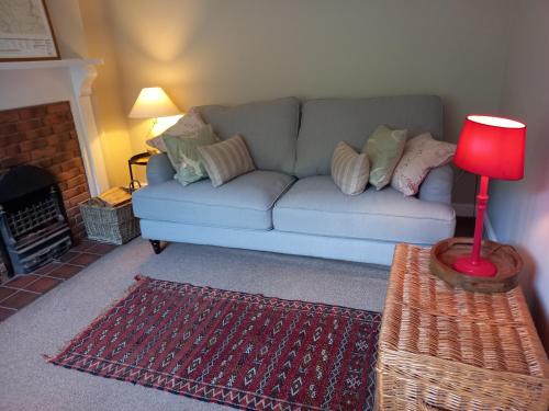 a living room with a couch and a red lamp at Sheila's Cottage in Lynton