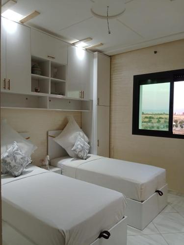 two white beds in a room with a window at Résidence Al Qaraouiyine in Fès