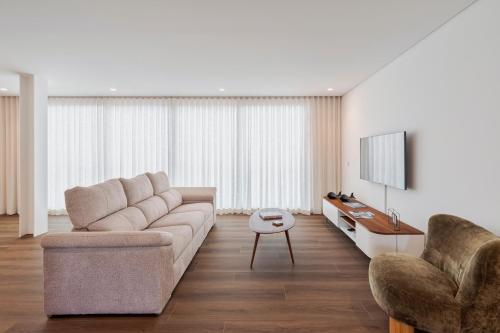 a living room with a couch and a tv at Penthouse 9 in Setúbal