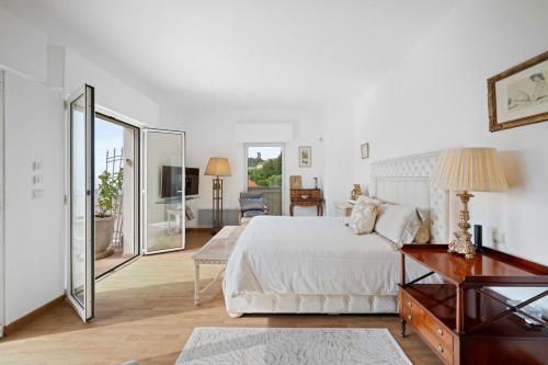 Villa Julia - Vue Mer - Jardin - Parking privé - في لا توربي: غرفة نوم بيضاء مع سرير وغرفة معيشة