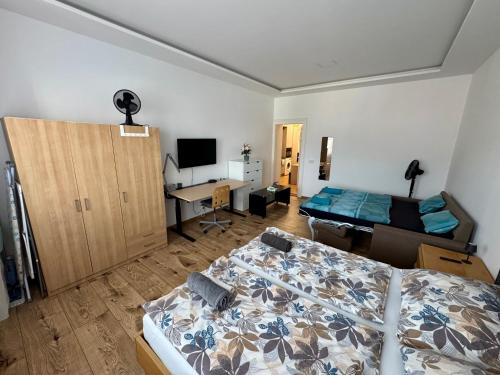 a bedroom with a bed and a desk with a computer at Apartment with Workspace and TV in Nový Lískovec