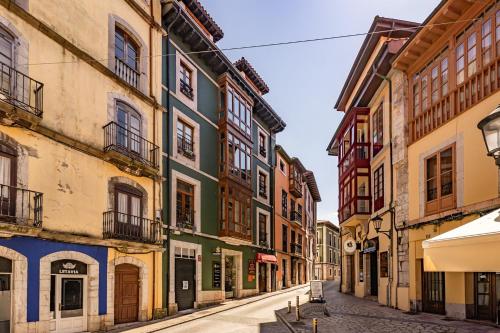 an alley in an old town with colorful buildings at Apartamentos San Roque en Llanes by megustarural in Llanes