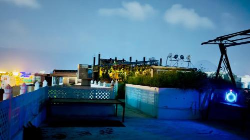 a bench sitting on top of a building at night at Hotel White House - A Family Homestay in Pushkar