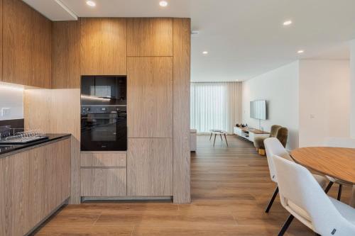 a kitchen with wooden cabinets and a table and a dining room at Penthouse 9 in Setúbal