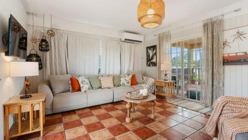 a living room with a couch and a table at Yellow Beach House Unit B - 2 min walk from the Beach in Aguada