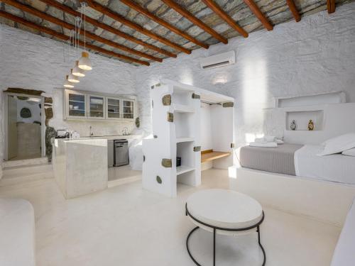 a white room with a bed and a table at CALDERA CASABLANCA in Ano Meria