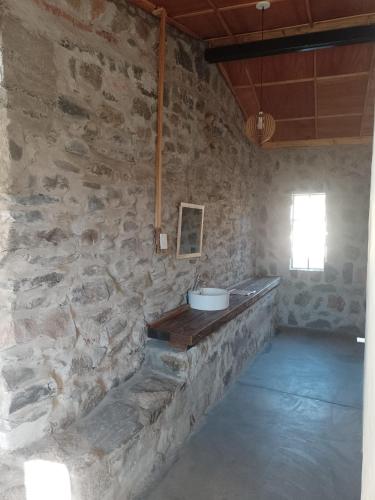 a room with a stone wall with a sink in it at Finca Las Higueras in Cafayate