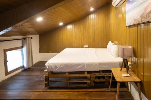 une chambre avec un lit dans un mur en bois dans l'établissement The Ascent at La Villa Boutique Hotel, à Trofwi