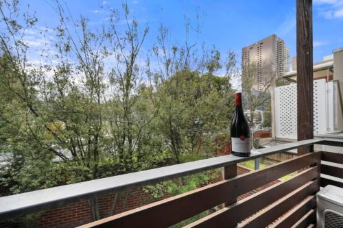 a bottle of wine sitting on the ledge of a balcony at Comfy Box Hill Unit Near Station and Restaurants in Box Hill