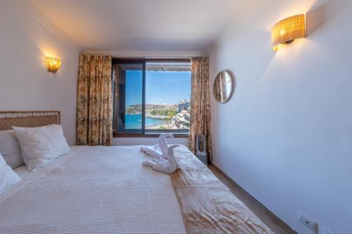 a bedroom with a large bed with a window at Abora Mar - Beach Apartment in Patalavaca