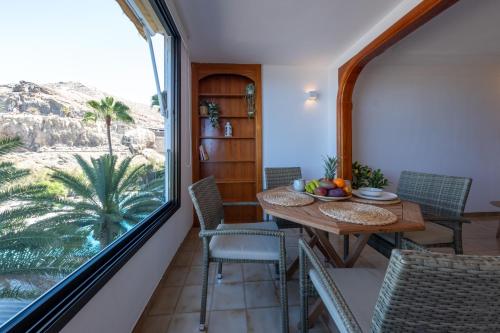 a dining room with a table and a large window at Abora Mar - Beach Apartment in Patalavaca