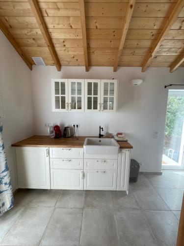 a kitchen with white cabinets and a sink at Quinta Madrugada Burgau in Luz