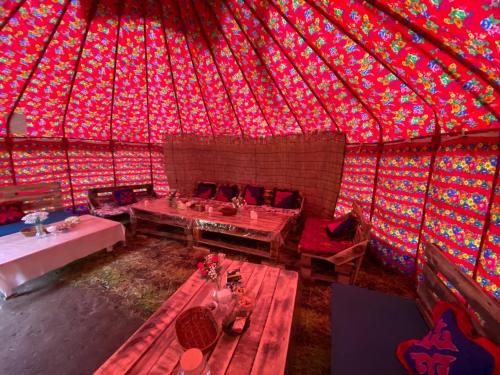 a room with a red ceiling with tables in it at Aalam yurt camp Altyn-Arashan in Mineralʼnyy Istochnik Altyn-Arasan