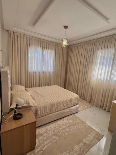 a bedroom with a bed and a table and a window at New 3 bedrooms apartment steps away from bus station in Tangier