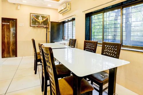a dining room with a white table and chairs at Super Collection O Airport Metro Andheri East in Mumbai