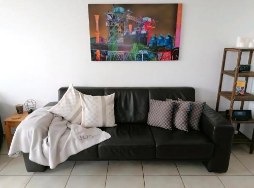a black leather couch with pillows on top of it at Ferienwohnung Auszeit im Grünen in Sprockhövel