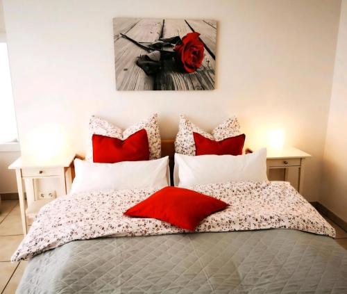 a bedroom with a bed with red and white pillows at Ferienwohnung Auszeit im Grünen in Sprockhövel