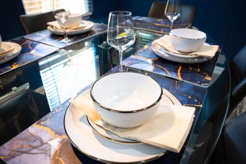 a table with plates and bowls and glasses on it at Cozy Cute Home 2BD and 1BR in Cypress