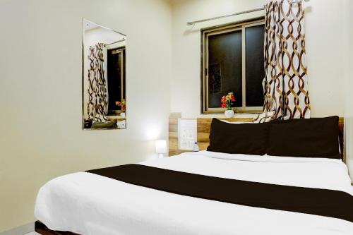 a bedroom with a large white bed and a window at Super Collection O Airport Metro Andheri East in Mumbai