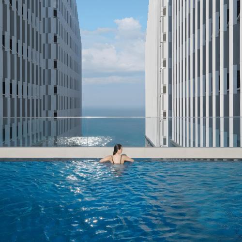 a woman in a swimming pool in a city at The Raclay Mandala Cham Bay Mui Ne - Phan Thiet in Phan Thiet